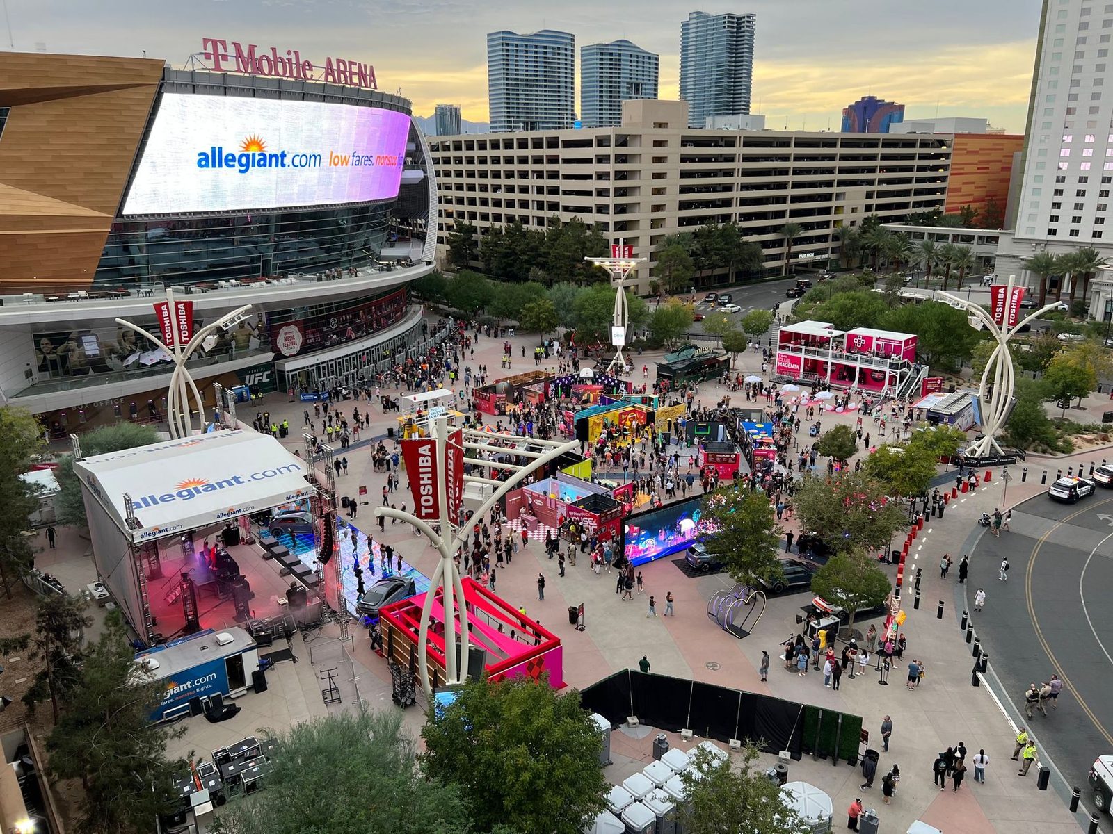 Aerial view of Toshiba Plaza during the iHeartRadio Music Festival House of Music, with T-Mobile Arena, the Allegiant activation stage, and Toshiba banners in frame.