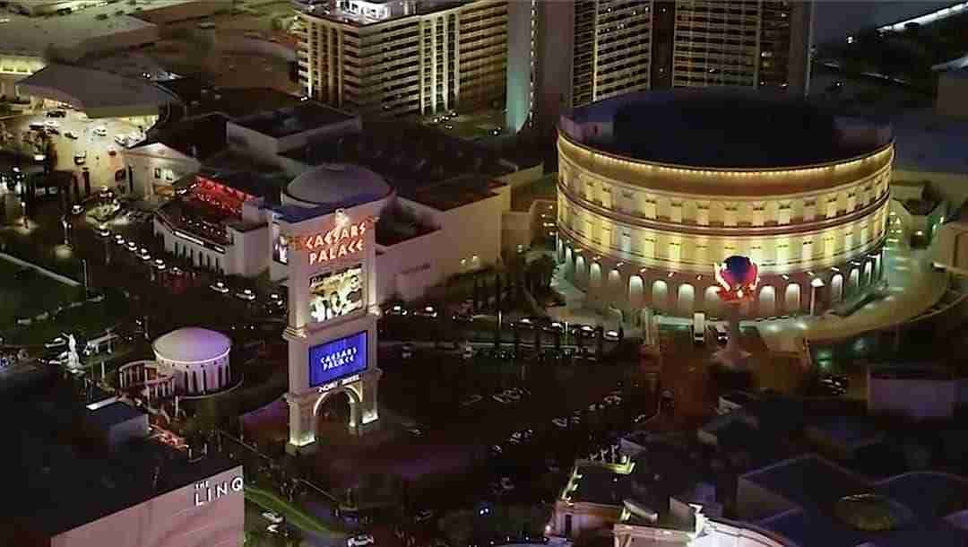 The Colosseum and the Caesars Palace marquee at night on the Las Vegas Strip.