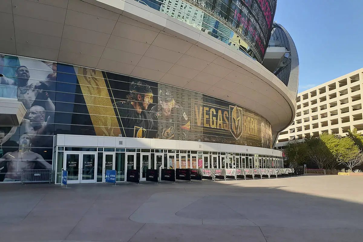 Exterior window signage at T-Mobile Arena carrying Vegas Golden Knights and UFC graphics.