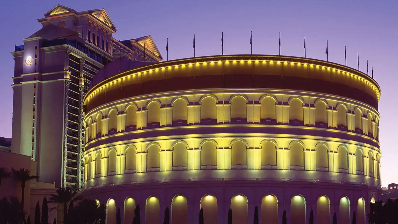The Colosseum at Caesars Palace lit gold at dusk.