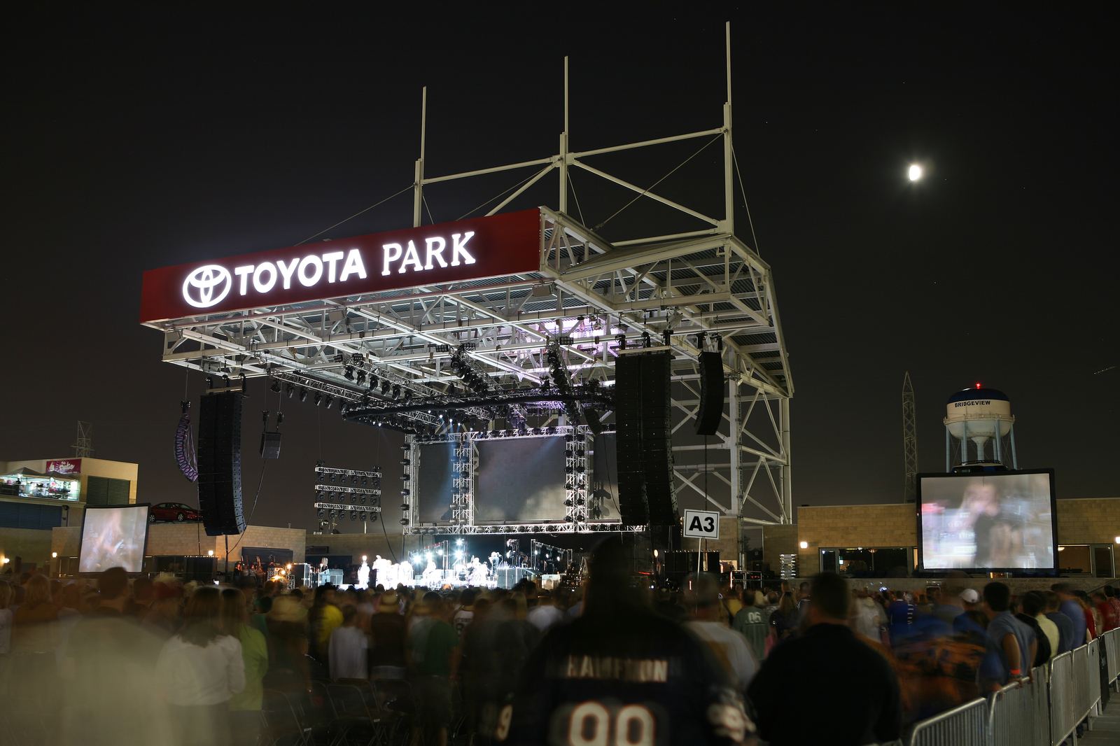 The Toyota Park concert stage lit at night, with the branded canopy sign glowing.
